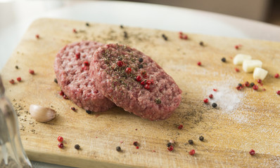2 raw beef steaks with spices on wooden  Board, garlic, spices on the table, beef cutlets, kitchen