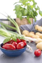 young potatoes and cherry tomatoes and fresh onions. Ingredients for lunch.