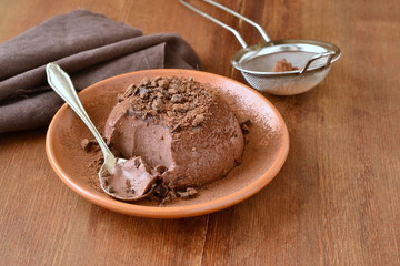 Cocoa panna cotta decorated with black grated chocolate, delicious dessert