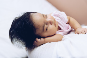 Fototapeta na wymiar Baby girl sleeping in mother's arms
