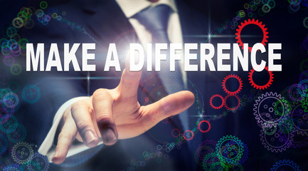 A businessman pressing a Make A Difference business concept on a graphical display of cogs