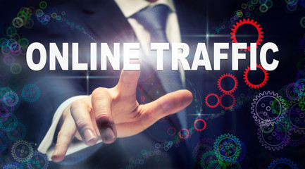 A businessman pressing a Online Traffic business concept on a graphical display of cogs