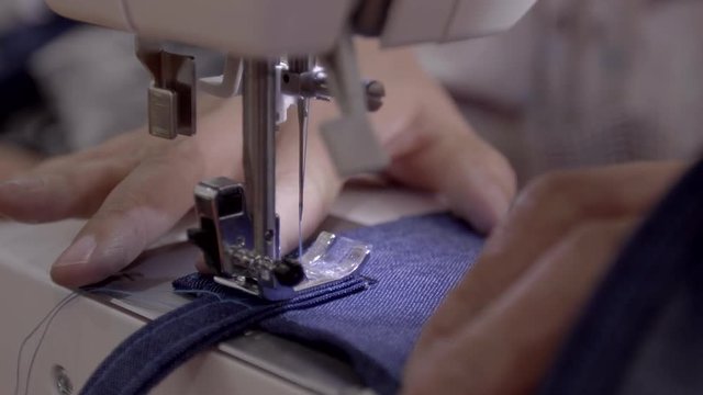 Close up footage of a woman sewing a apron with a sewing machine