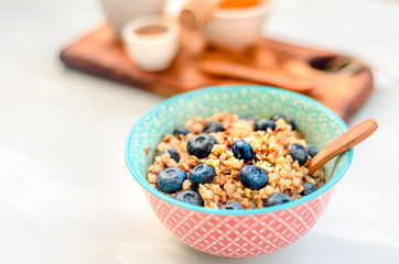 High protein healthy breakfast, buckwheat porridge with blueberries, flax seeds and honey