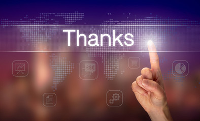 A hand selecting a Thanks business concept on a clear screen with a colorful blurred background.
