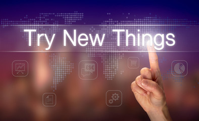 A hand selecting a Try New Things business concept on a clear screen with a colorful blurred background.