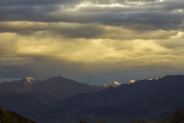 Fototapeta premium sunlight in the evening sky over snowy mountains
