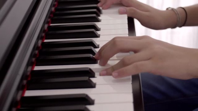 Young asian girl practicing the piano in her room.