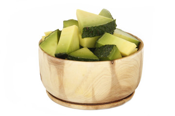 slices of avocado in wooden cup isolated on white