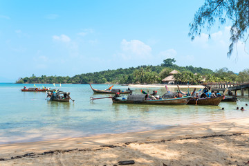 Kids swimming, sea Gypsies on their long-tail boats  at the east-side beach named Ao Mae Mai on the island Ko Phayam 