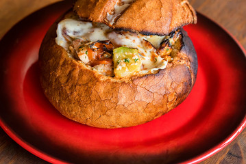 Meat stew served in bread bowl on plate