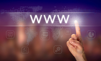A hand selecting a www business concept on a clear screen with a colorful blurred background.