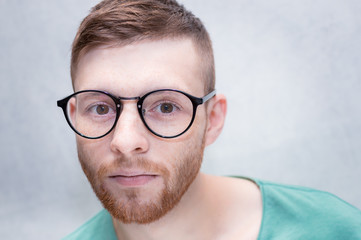 Portrait of a young man with glasses close-up. concept of poor vision.