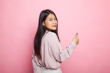 Young Asian woman turn back thumbs up.