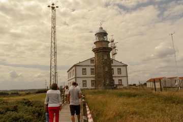 familia paseando con casa faro al fondo