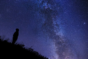 Silhouette of a lonely man watching the stars and the Cygnus Rift in Tuscany
