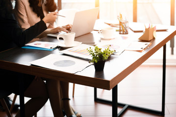 The blurry light design background of business workers are working  in office hour,plenty of business paper chart on table,warm light tone.