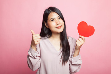 Asian woman thumbs up with red heart.