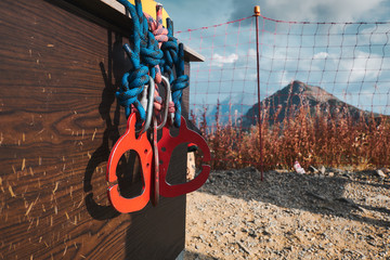 red carabines at scratched at mountain background. climbing safety system equipment