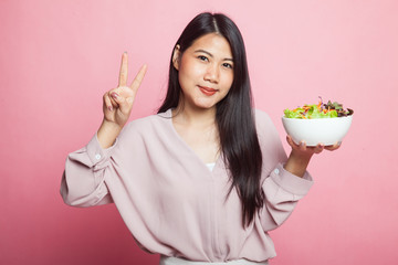 Healthy Asian woman show victory sign with salad.