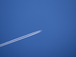 Trail of the plane against the blue sky