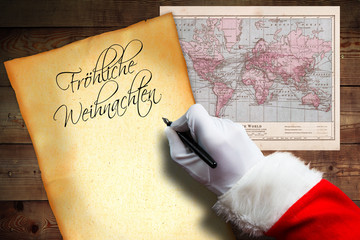 Hand vom Weihnachtsmann schreibt Weihnachtsgruß 