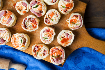 Raw pIzza rolls pastry on a wooden board