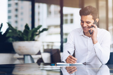 Smiling businessman is talking on phone