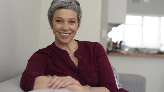 Portrait of sappy senior woman on couch looking at camera