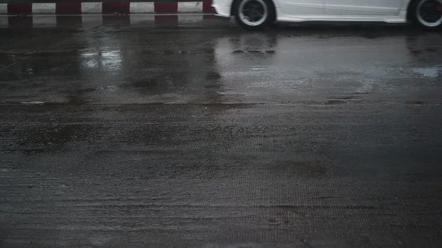 rain drops on asphalt road with car driving