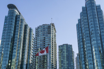 Canadian flag infront of modern glass building in Vancouver