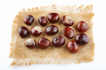 Many peeled chestnuts lie on hessian. Horse-chestnuts