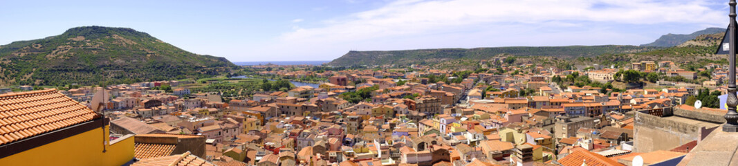 Naklejka na ściany i meble Bosa, Italy - Panoramic view of the historic town of Bosa at the western coast of Sardegna by the Fiume Temo river and Bosa Marina in the background