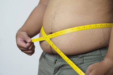Fat man holding a Plastic tape measure for Calculating body fat.