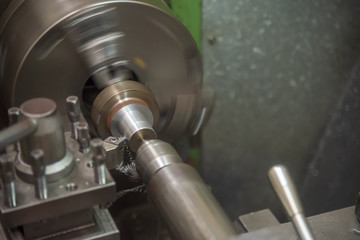 The  operation of lathe machine cutting the steel shaft in the light blue scene.