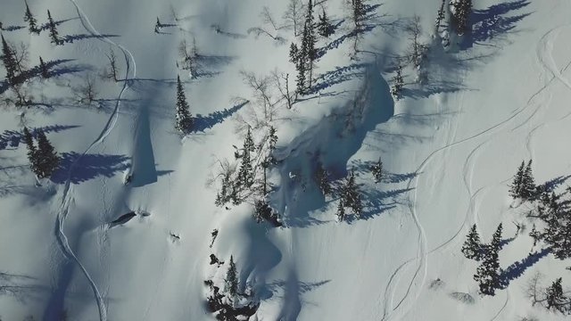 Aerial from drone man skier ski touring in the snowy mountains uphill in a line