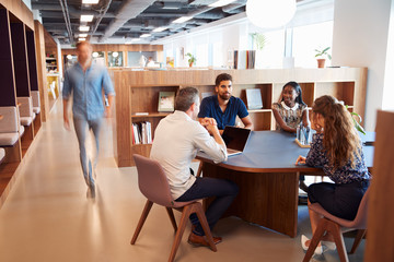 Casually Dressed Businessmen And Businesswomen Having Informal Meeting In Modern Office