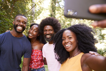 Four black adult friends take a selfie during a forest hike
