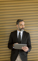 Middle age businessman with tablet in the office