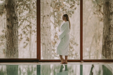 Pretty young woman standing by swimming pool