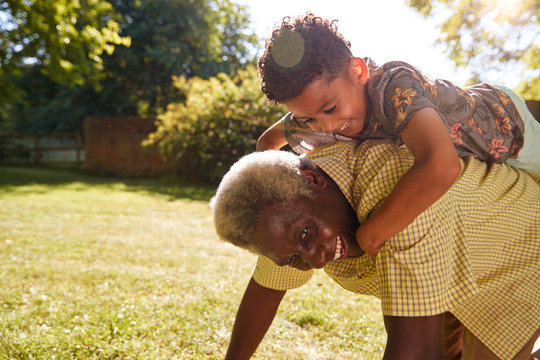 Senior Black Man With Grandson Riding On His Back