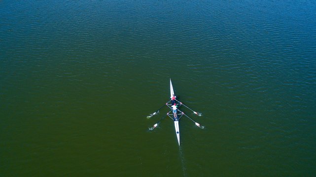 Boat Coxed Four Rowers Rowing On The Tranquil Lake. Aerial View Of Rowing And Rowers.