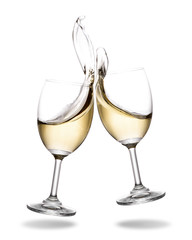 Cheering white wine with splashing out of glass isolated on white background.