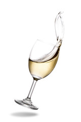 White wine splashing out of glass isolated on white background.