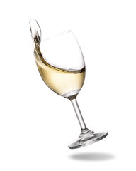 White wine splashing out of glass isolated on white background.