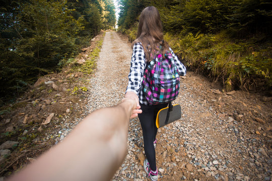 Follow Me. Travel Concept. Back View Of Young Woman With Backpack Outdoors Discovering Jungle Holding Boyfriend Hand.