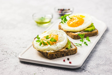 Avocado, cream cheese and fried egg sandwich. Selective focus, space for text.
