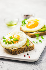 Avocado, cream cheese and fried egg sandwich. Selective focus, space for text.