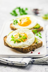 Avocado, cream cheese and fried egg sandwich. Selective focus, space for text.