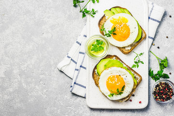 Avocado, cream cheese and fried egg sandwich.Top view, space for text.